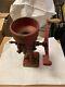 Antique cast iron grain/coffee grinder marked 2mb, 2mc, 16 inches tall red faded