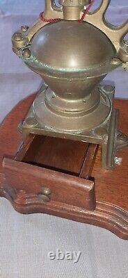 Antique coffee grinder in brass, cast iron and wooden base