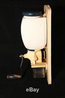 Old vintage wall coffee grinder with blue dutch windmill motif